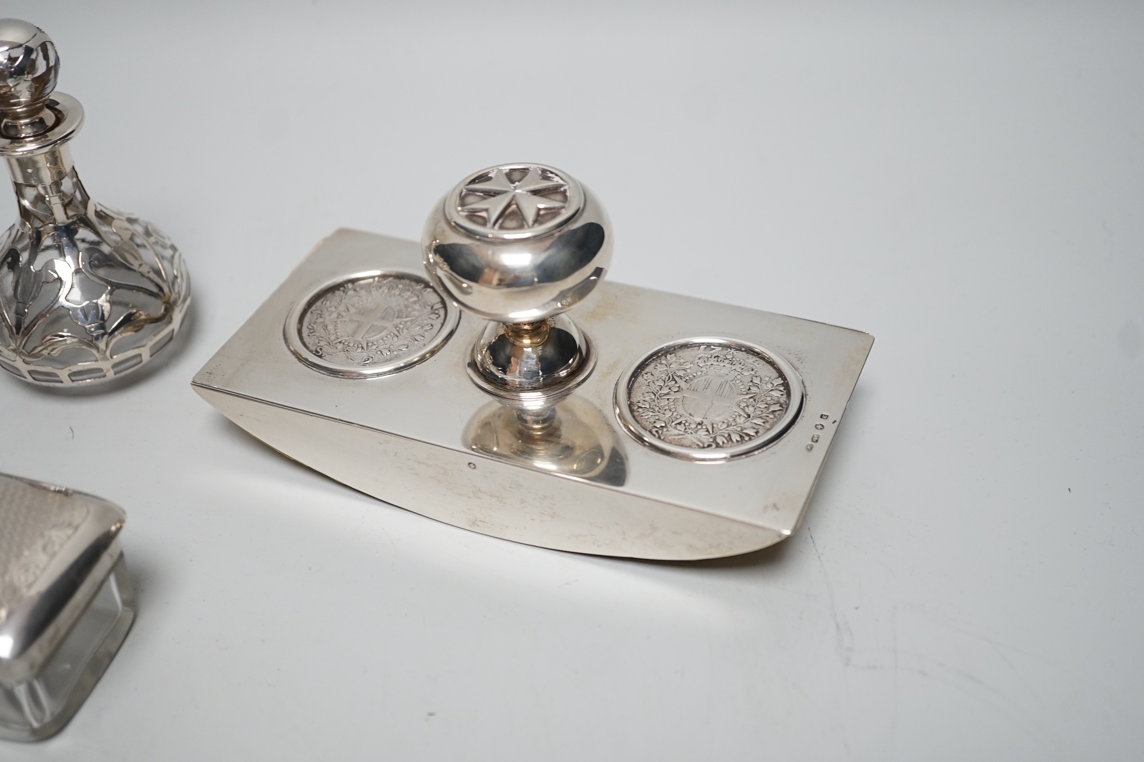 A George V silver two handled bowl, 14.6cm over handles, a white metal overlaid glass scent bottle (a.f.), a silver mounted blotter and a silver mounted glass toilet jar.